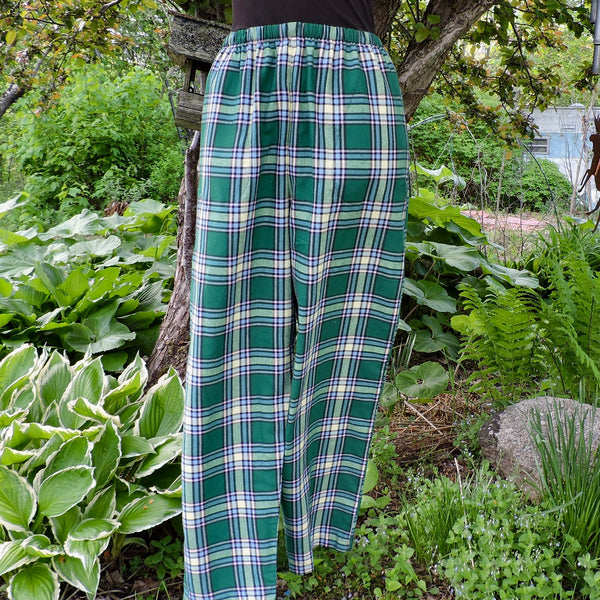Alberta Tartan pants worn by a person standing in a garden.